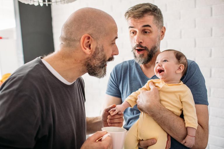 Male couple with baby laughing