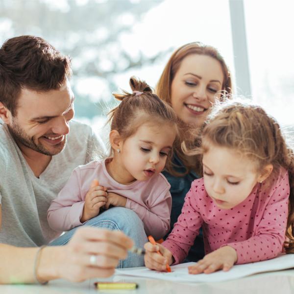 Dad, mum and two daughters drawing at the table